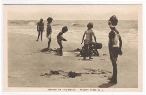 Children Playing Around 5 Mounds Of Sand